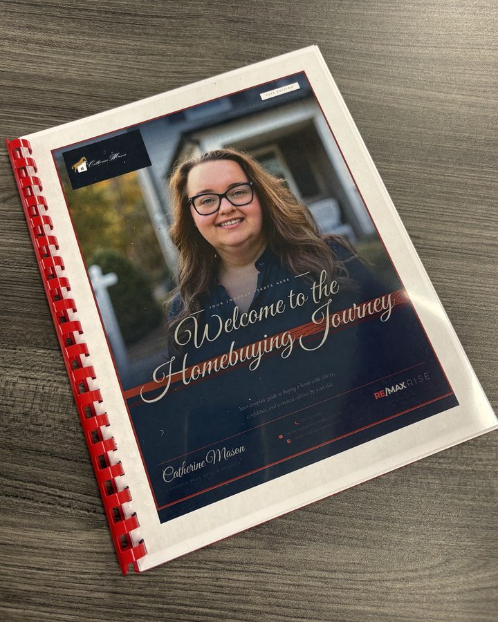 Catherine Mason's printed, spiral-bound Buyer Guide, Welcome to the Homebuying Journey, on a wood table